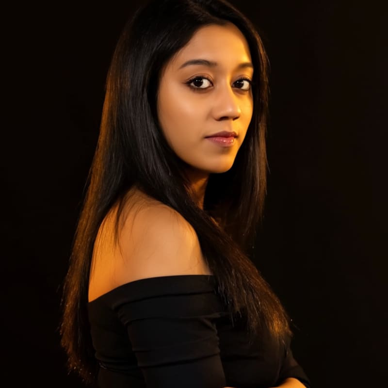 Amelia Gagne, co-founder and CEO of Kief Studio, in a warm-lit studio portrait against a black background.
