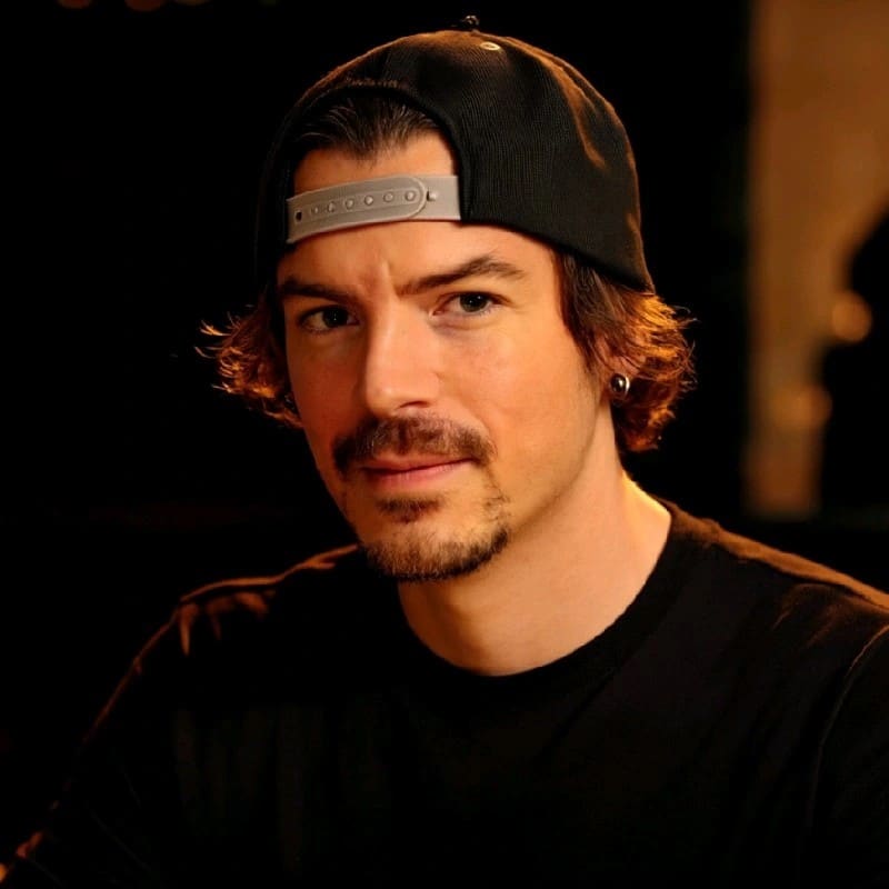 Brian Gagne, co-founder and CTO of Kief Studio, in a warm-lit portrait wearing a backwards black cap and a black T-shirt.